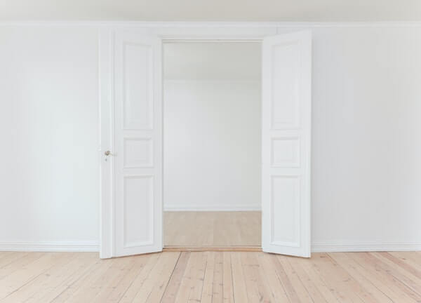 empty white room with light wooden flooring