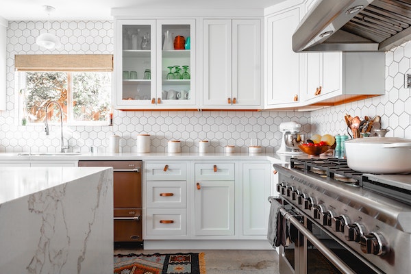 Kitchen with white cabinets and a large gas range.