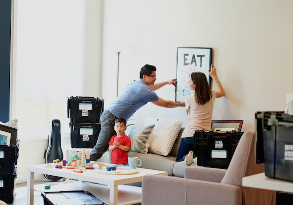 Family hanging a picture in the living room.